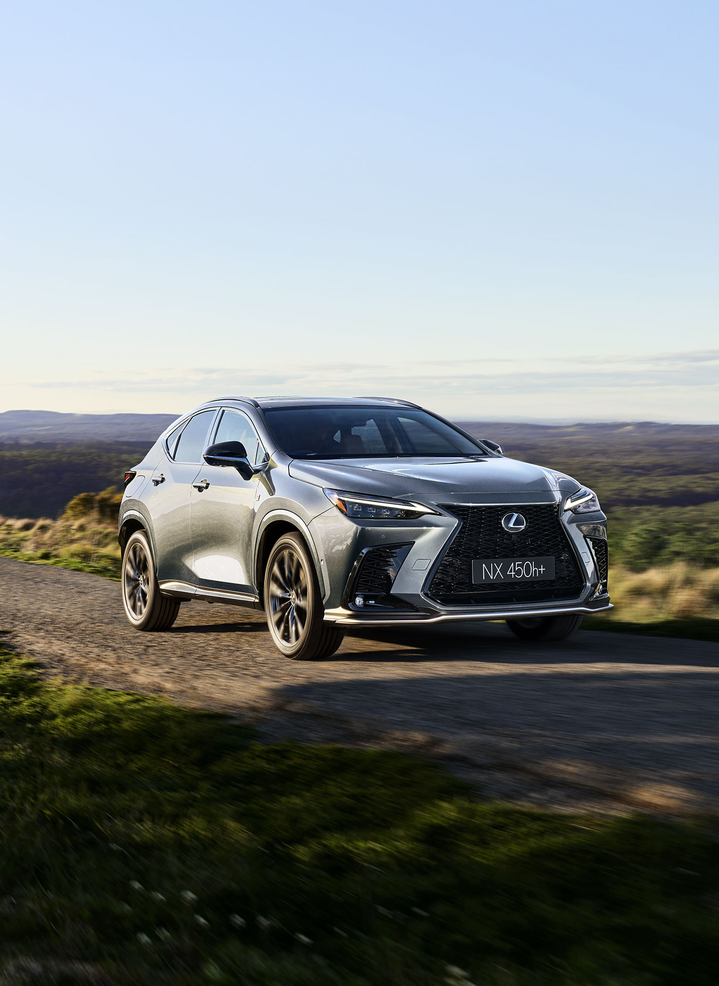 Lexus NX 450h+ driving along a country road